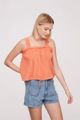 Musculosa color salmón con breteles finos y detalle de puntilla en el escote.