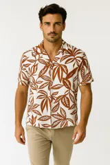 Camisa de viscosa con estampado de hojas de palmera en tonos azul y blanco, con cuello clásico y manga corta.