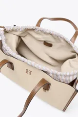 Bolso maxi shopper de hombro color beige con detalles en cuero marrón. Tiene doble asa de cuero y bolsa de tela extraíble con cierre fruncido.