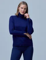 Polera de punto fino marca Nienty, color azul marino, con cuello alto y mangas largas con detalle de tajo en los puños.