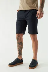 Bermuda de gabardina color beige, corte chino, con bolsillos laterales y traseros, cierre con cremallera y botón, presillas para cinturón y logo bordado.