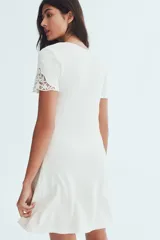Vestido corto blanco de punto interlock con escote cuadrado, mangas cortas con detalles de encaje y bordado floral en el pecho.
