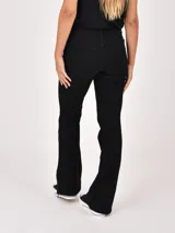 Jean negro de corte flare, con tiro medio y diseño clásico de cinco bolsillos.