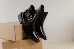 Botines Chelsea color beige con elásticos laterales negros, punta cuadrada, detalle de hebilla lateral y tacón bloque bajo.