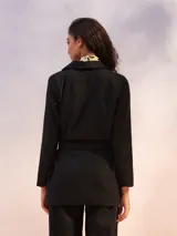 Blazer color crema de manga larga, con solapas amplias y cinturón para ajustar a la cintura.