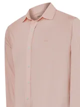 Camisa celeste con finas rayas verticales blancas, de manga larga y cuello camisero.