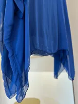 Blusa azul francia de seda italiana, con cuello a la base, corte asimétrico y musculosa integrada.
