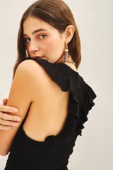 Musculosa negra tejida en hilo de algodón con punto desagujado, calce al cuerpo y volados en las sisas.
