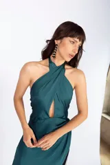Vestido largo de seda lavada color azul marino, con escote halter cruzado, abertura en la falda y flecos en el ruedo.