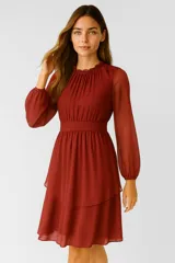 Vestido corto negro de poliéster con cuello polera, mangas abullonadas y falda con volados.