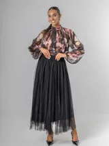 Falda estilo ballet core confeccionada en gasa negra con pequeños destellos que aportan brillo sutil y movimiento. Tiene cintura elastizada.