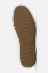 Zapatilla urbana de cuero sintético color negro, con cordones y suela de goma color crema.
