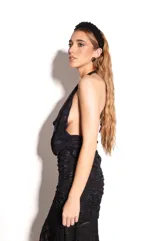 Top negro de encaje con cuello halter y corte fluido en el pecho.