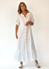 Vestido largo color rosado de lino, con cuello camisero, mangas 3/4 con botón y ruedo con volantes.