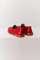 Mocasín de cuero color marrón claro, con detalle de flecos y borlas en la parte delantera. Diseñado en Uruguay y fabricado en Brasil.