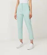 Pantalón zanahoria color celeste pastel, de lino, con pliegues en la cintura, bolsillos delanteros y amarre en la barra.