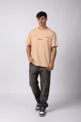 Remera color durazno con cuello redondo y mangas cortas. Estampas con tipografía manuscrita en el frente y la espalda.