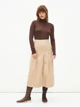 Falda midi color beige con cintura alta y pliegues frontales.