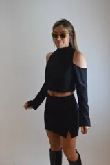 Mini falda negra de diseño ajustado con detalles asimétricos y brilante.