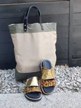 Bolso grande de diseño rústico en tonos beige y verde militar, con asas de cuero negro.