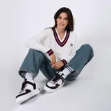 Zapatillas de media caña blancas con detalles en negro y lila. Cierre con cordones negros y tira de velcro blanca con la palabra "Friends".