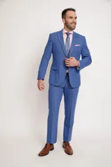 Traje de vestir azul con saco de dos botones, solapa de muesca, dos bolsillos con solapa y bolsillo de ojal en el pecho. Pantalón de corte recto con bolsillos laterales y traseros.