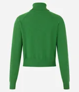 Blusa de punto color blanco, con cuello alto, manga larga y diseño liso.