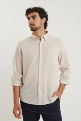 Camisa azul marino de lino y algodón, con cuello abotonado, manga larga con puños enrollados, bolsillo de parche en el pecho y cierre frontal con botones.