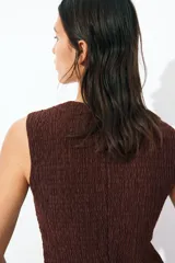 Chaleco marrón de punto texturizado con cuello redondo y botones frontales.