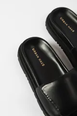 Sandalias negras con plataforma y tira ancha acolchada sobre el empeine.