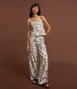 Pantalón wide leg de sarga con estampado animal print dálmata, trabillas en la cintura, cierre con botón y cremallera, y bolsillos delanteros y traseros.