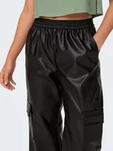 Pantalón cargo negro de cuero sintético, tiro medio, con cintura y ruedos elastizados y bolsillos laterales.