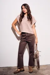 Chaleco de punto color beige con lurex, de corte recto y mangas cortas. Tejido calado con pequeños agujeros.