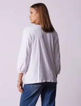 Blusa blanca de algodón y poliéster, marca Ruby Rd, con escote en V y bordado floral en el frente. Tiene mangas 3/4 con puños elastizados.