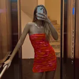 Minivestido ajustado con estampado floral en tonos naranja y rojo, con escote recto y fruncido en todo el cuerpo.