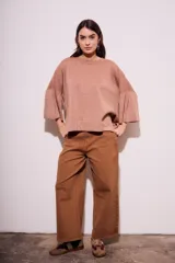 Sweater color salmón de tejido de punto con lurex, corte oversize, cuello redondo y mangas 3/4 acampanadas.