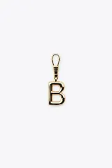 Dije dorado en forma de la letra A, con mosquetón para colgar en carteras o pulseras.