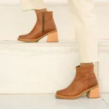 Bota corta de cuero negro, con taco cuadrado y punta cuadrada. Presenta un panel texturizado en el talón y cierre lateral.