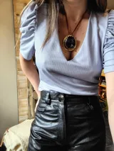 Blusa celeste de lurex con escote en V y mangas abullonadas.