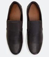 Championes slip on de cuero color marrón oscuro con suela blanca de goma.