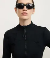 Campera deportiva negra de manga larga y cuello alto, con cierre frontal. Presenta recortes en el torso y bolsillos laterales con cierre.