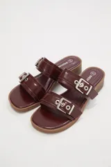 Sandalias negras con doble tira y hebillas plateadas.