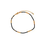 Tobillera de cordón negro con detalles de acero quirúrgico con baño de oro de 18k.