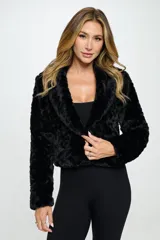Chaqueta corta de piel sintética color negro, con cuello solapa y cierre con un único botón.