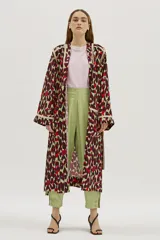 Bata larga estampada con diseño abstracto en tonos borgoña, verde y rojo, con vivos en contraste color crema. Tiene corte recto y amplio, bolsillos delanteros y lazo para ajustar en la cintura.