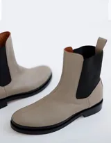 Bota Chelsea color crema de cuero vacuno, con elástico lateral negro, suela de cuero y taco de 2,5 cm. Hecha a mano en Argentina.