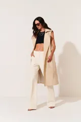 Trench color beige, con diseño clásico y corte largo.
