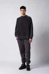 Buzo negro de frisa 100% algodón, con calce oversize y lavado gastado. Tiene costuras a contratono y recortes.