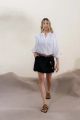 Camisa blanca de mangas 3/4 abullonadas, con cuello en V y cierre frontal con botones.