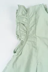 Conjunto de dos piezas color verde agua, compuesto por blusa sin mangas con volados en los hombros y pantalón largo con estampado de rayas verticales y cintura elástica. Incluye scrunchie a juego.